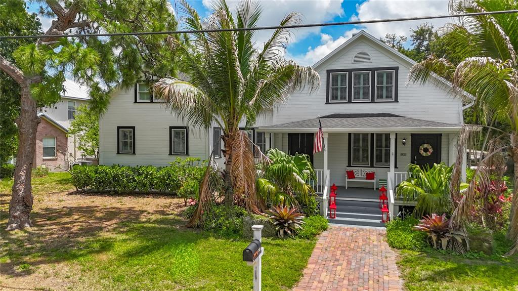 A white two-story house with a brick walkway and a front porch sits on grass — 3621 1ST AVENUE W, BRADENTON, FL