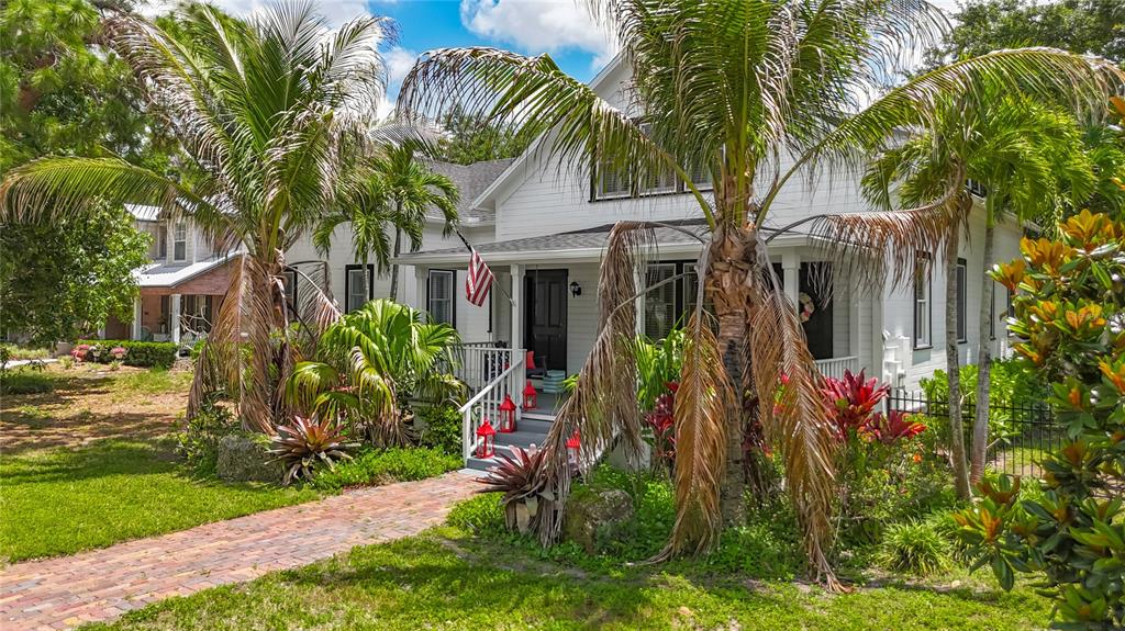 A white two-story house with a brick walkway and palm trees in the front yard — 3621 1ST AVENUE W, BRADENTON, FL