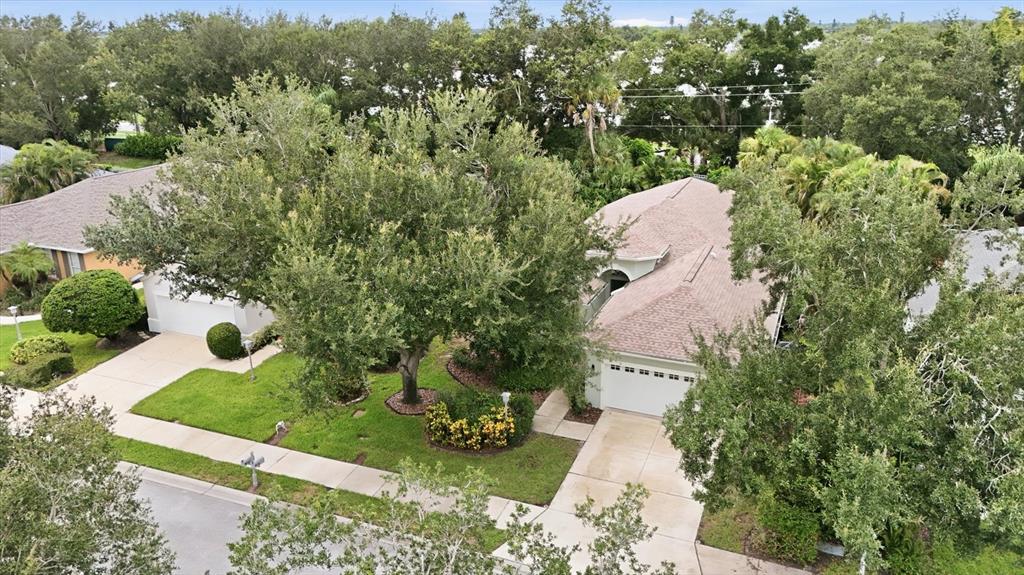 An aerial view shows two suburban houses with driveways, lawns, and mature trees — 5540 SIMONTON STREET, BRADENTON, FL