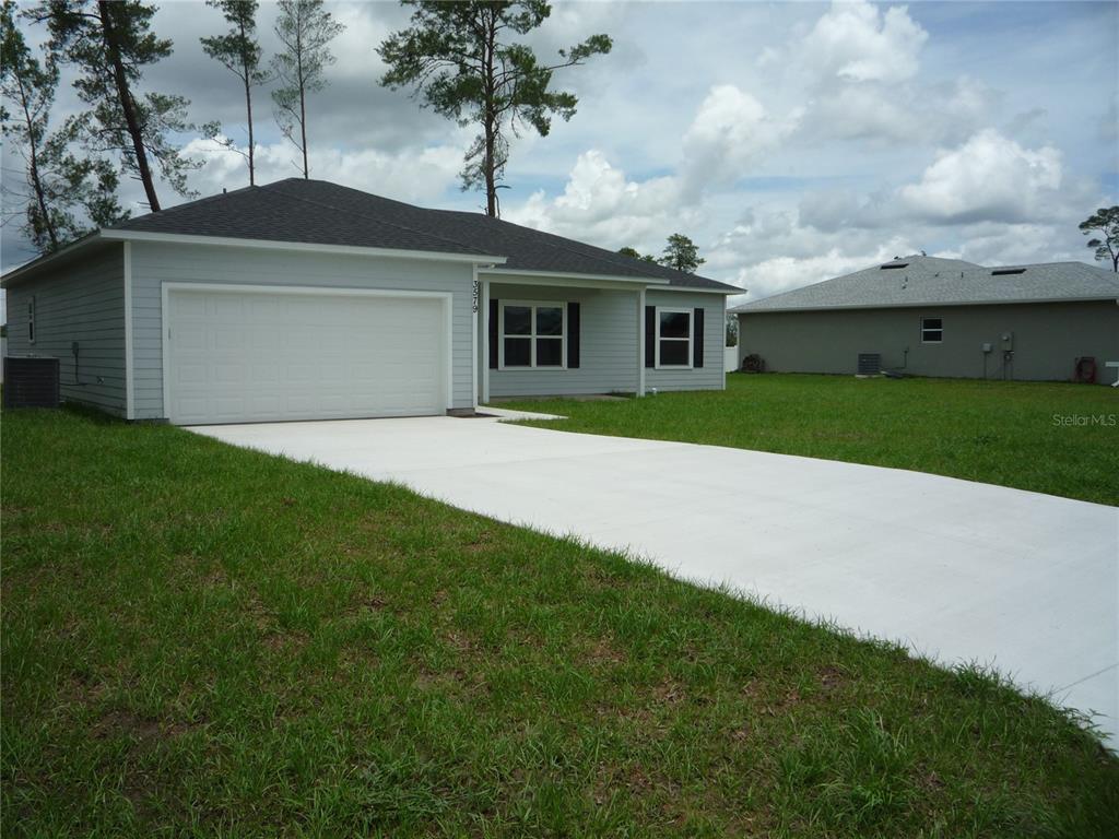 A light gray single-story house with a two-car garage and a concrete driveway — 3579 SW 128TH PL, OCALA, FL