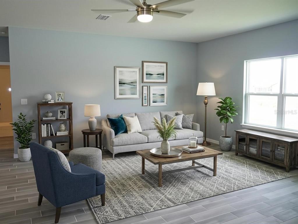 A living room features a gray sofa, a blue armchair, and a wooden coffee table — 3579 SW 128TH PL, OCALA, FL