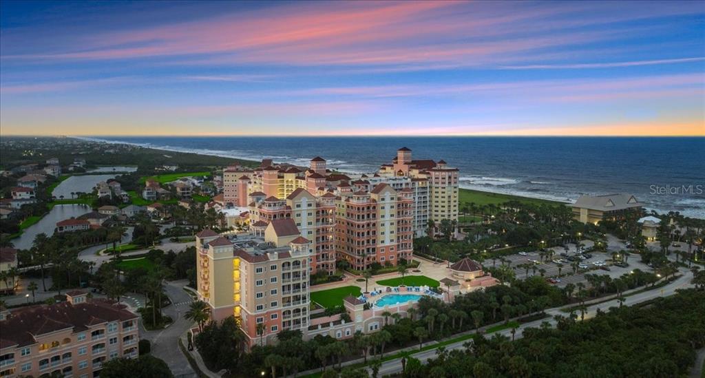 An aerial view shows a large multi-story resort complex situated along a sandy coastline — 200 OCEAN CREST DRIVE UNIT 137, PALM COAST, FL