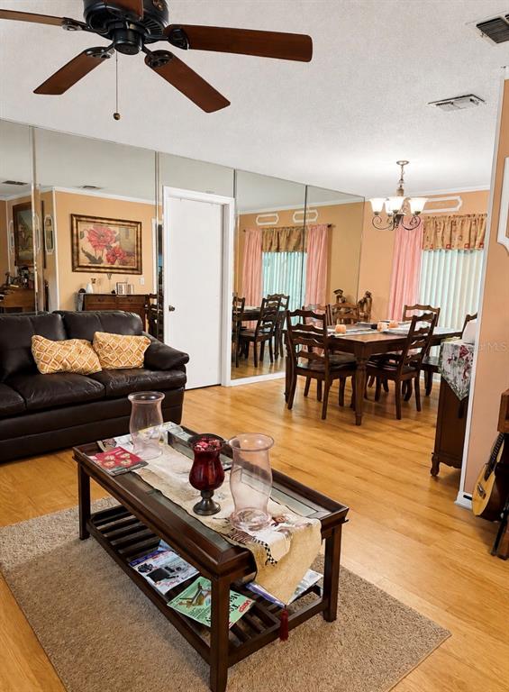 A living room features dark leather furniture, a coffee table, and a mirrored wall — 1012 FOREST CIRCLE, WINTER SPRINGS, FL