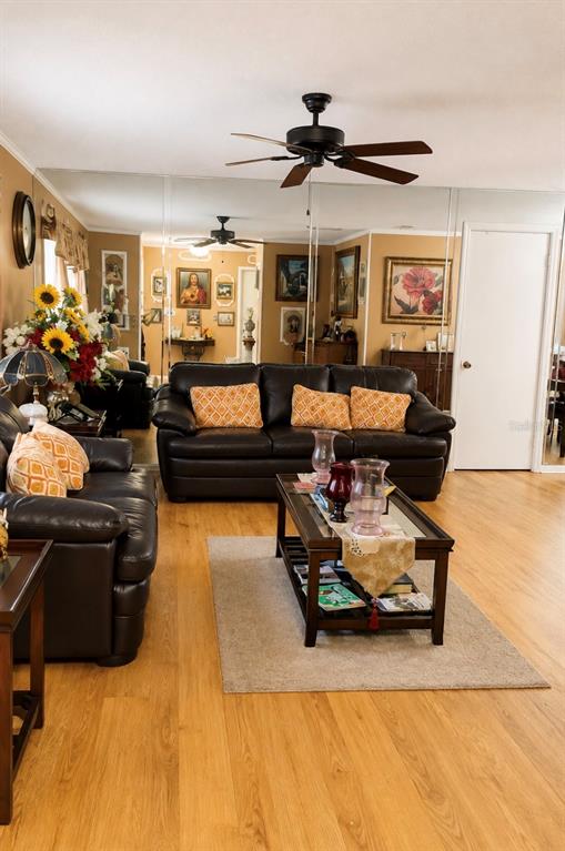 A living room with a dark leather sofa, a coffee table, and mirrored walls — 1012 FOREST CIRCLE, WINTER SPRINGS, FL