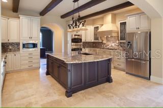 A kitchen features white cabinetry, a dark wood island, stainless steel appliances, and tile flooring — 1657 ENCLAVE COVE, LAKE MARY, FL