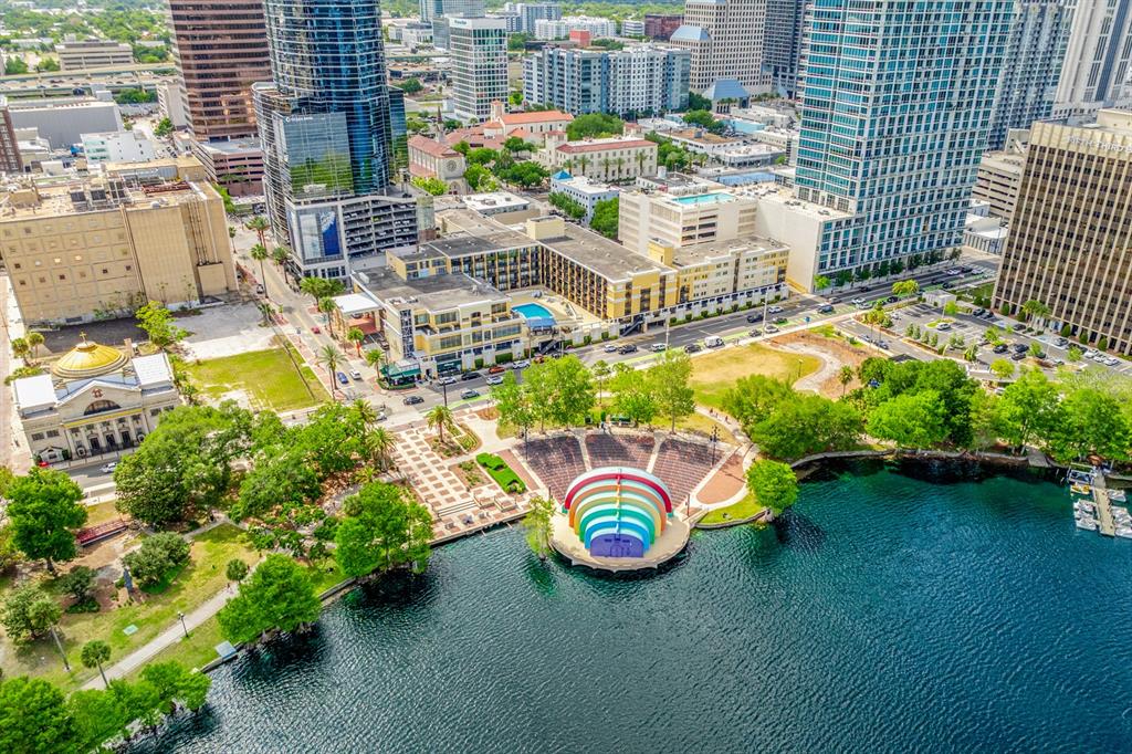 Aerial view of a city park featuring a rainbow-colored amphitheater stage on a lakefront — 151 E WASHINGTON STREET UNIT 218, ORLANDO, FL