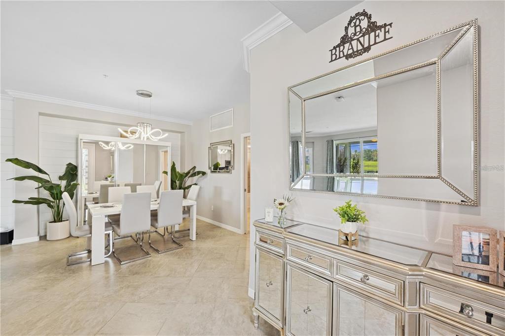A dining area with a mirrored sideboard and a large wall mirror in the foreground — 917 TIDEWATER SHORES LOOP, BRADENTON, FL