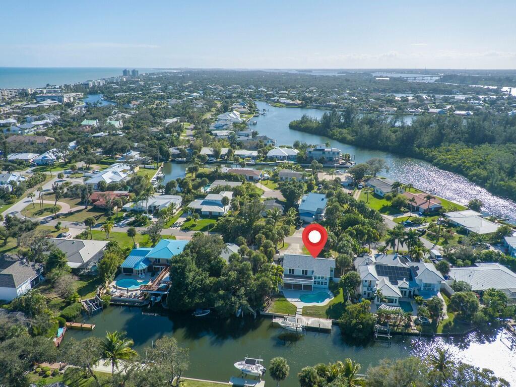 An aerial view shows a waterfront house with a pool and dock on a canal — 721 Shore Drive, Vero Beach FL 32963, VERO BEACH, FL
