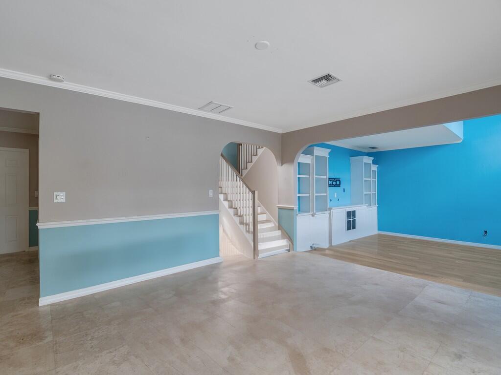 An interior view shows a tiled living area with a staircase and blue-painted walls — 721 Shore Drive, Vero Beach FL 32963, VERO BEACH, FL
