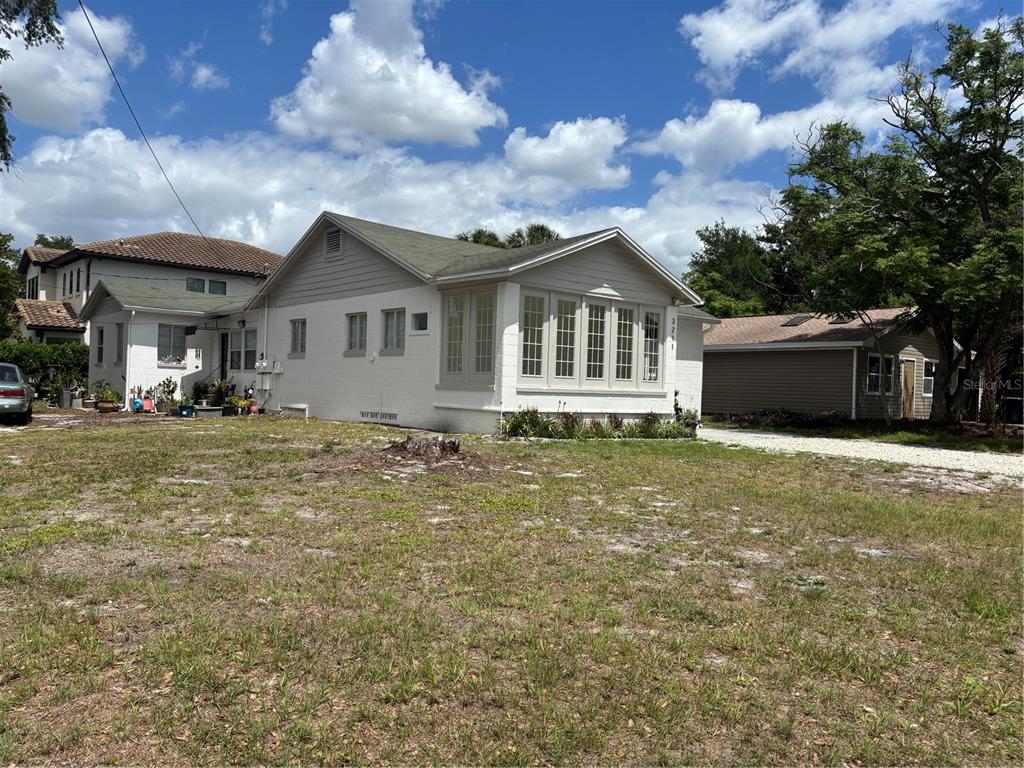 A white single-story house with a large front window and a gravel driveway — 3211 W NORTH A STREET, TAMPA, FL
