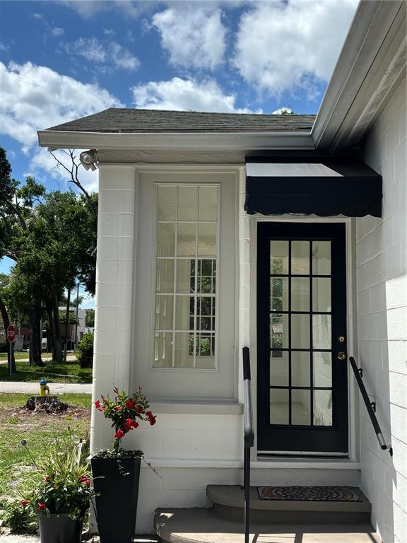A white concrete block building features a black door with glass panes and a matching awning — 3211 W NORTH A STREET, TAMPA, FL
