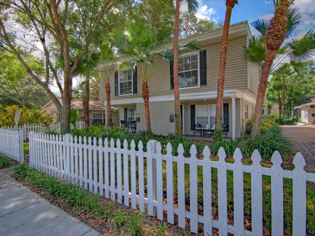 A two-story duplex with tan siding and a white picket fence in the front yard — 616 PALMER STREET UNIT B, ORLANDO, FL