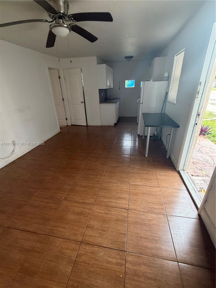 This room features brown tile flooring, a ceiling fan, and a small kitchen area — 410 N 58th Ave # 408, Hollywood FL 33021, HOLLYWOOD, FL