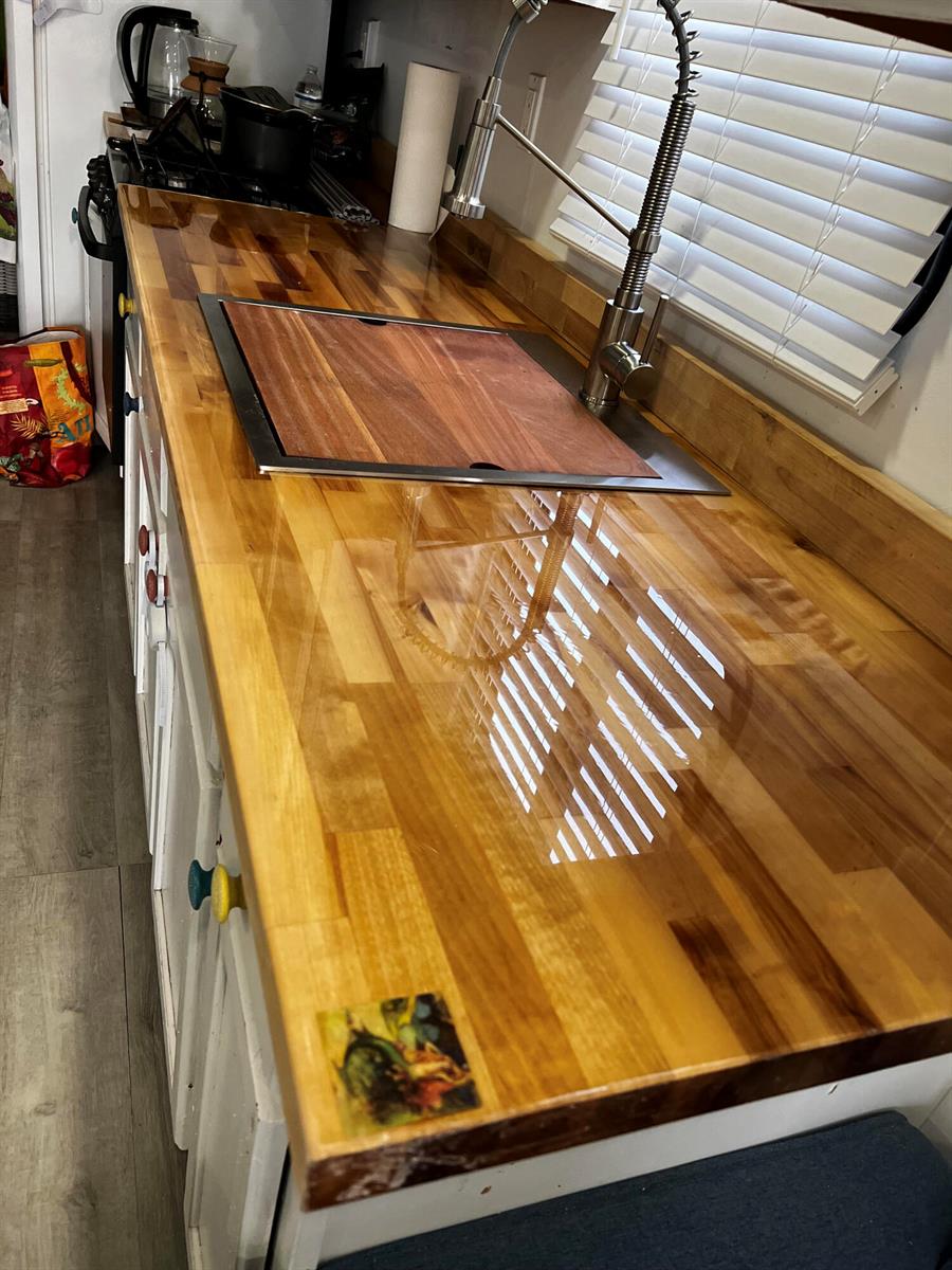 A kitchen counter features a glossy wood countertop, a stainless steel sink, and white cabinets — 1801 N Roosevelt Boulevard N, Key West FL 33040, KEY WEST, FL