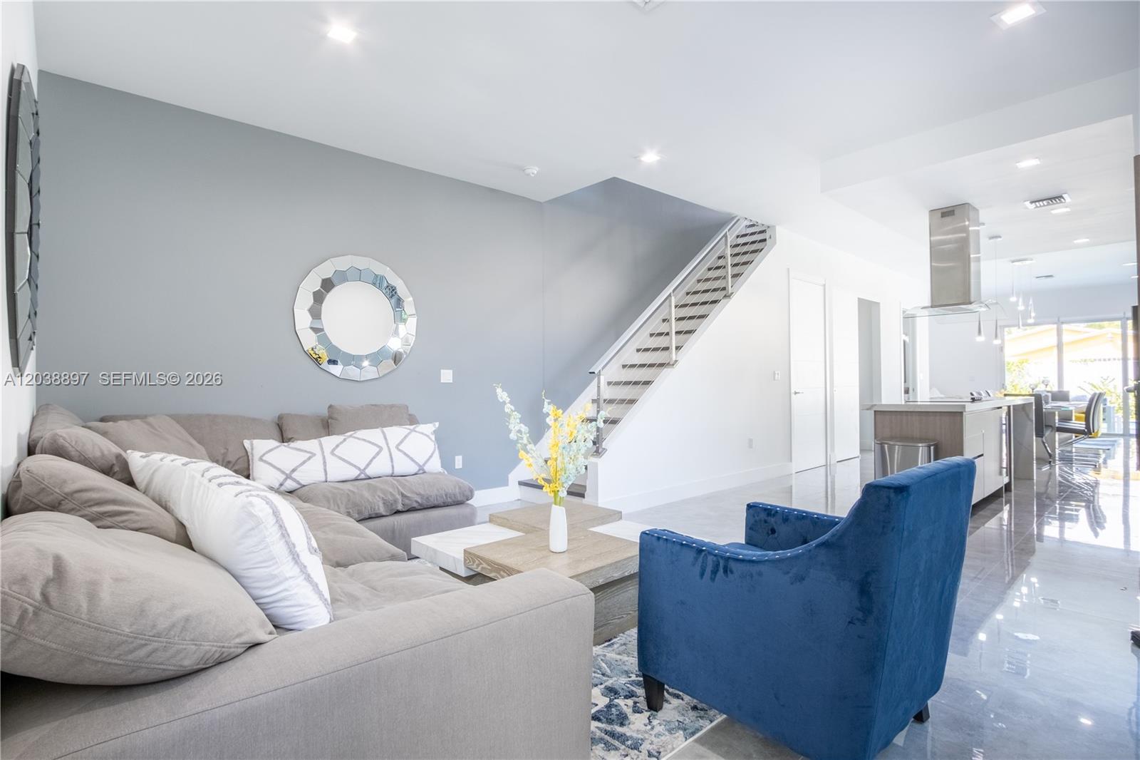 A living room features a grey sectional sofa, a blue armchair, and a staircase — 3461 SW 25th St # B, Miami FL 33133, MIAMI, FL