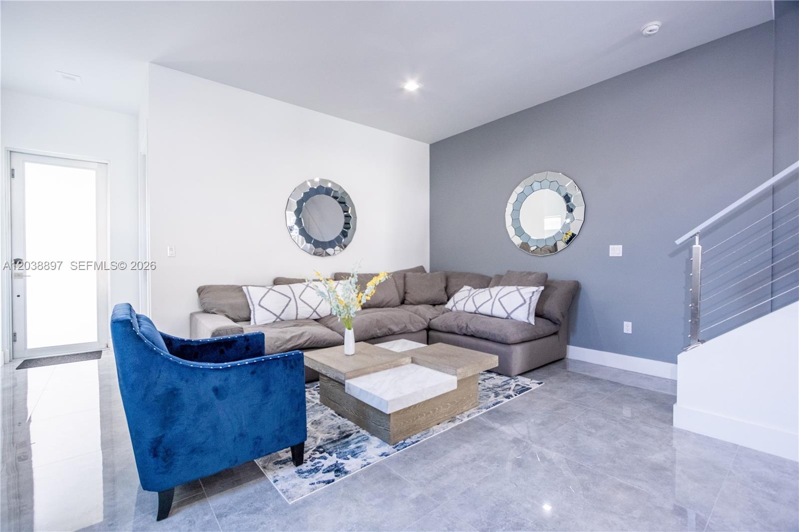 A living room features a grey sectional sofa, a blue velvet chair, and two round mirrors — 3461 SW 25th St # B, Miami FL 33133, MIAMI, FL
