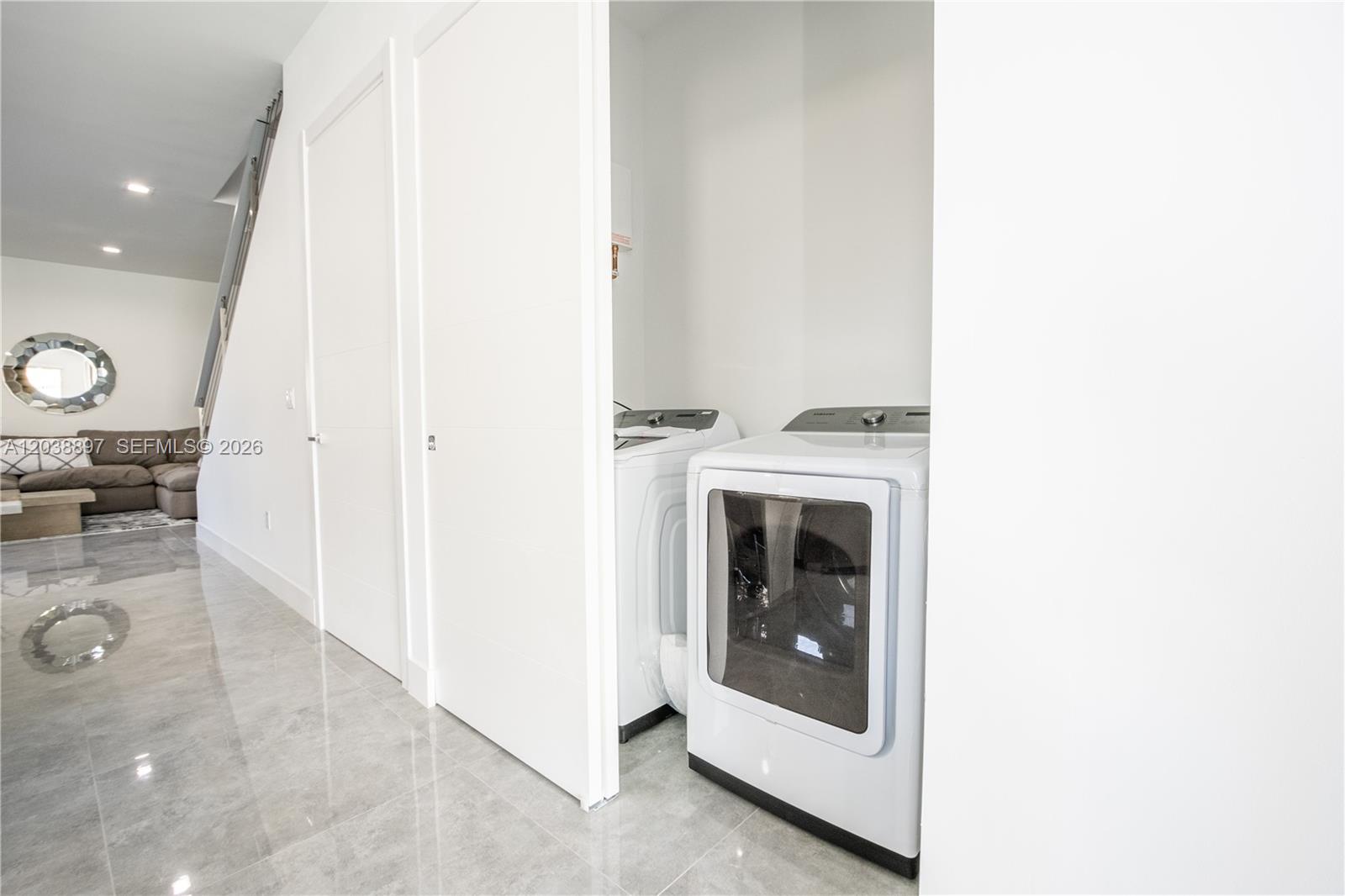 A laundry closet with a washer and dryer is located next to a living area — 3461 SW 25th St # B, Miami FL 33133, MIAMI, FL