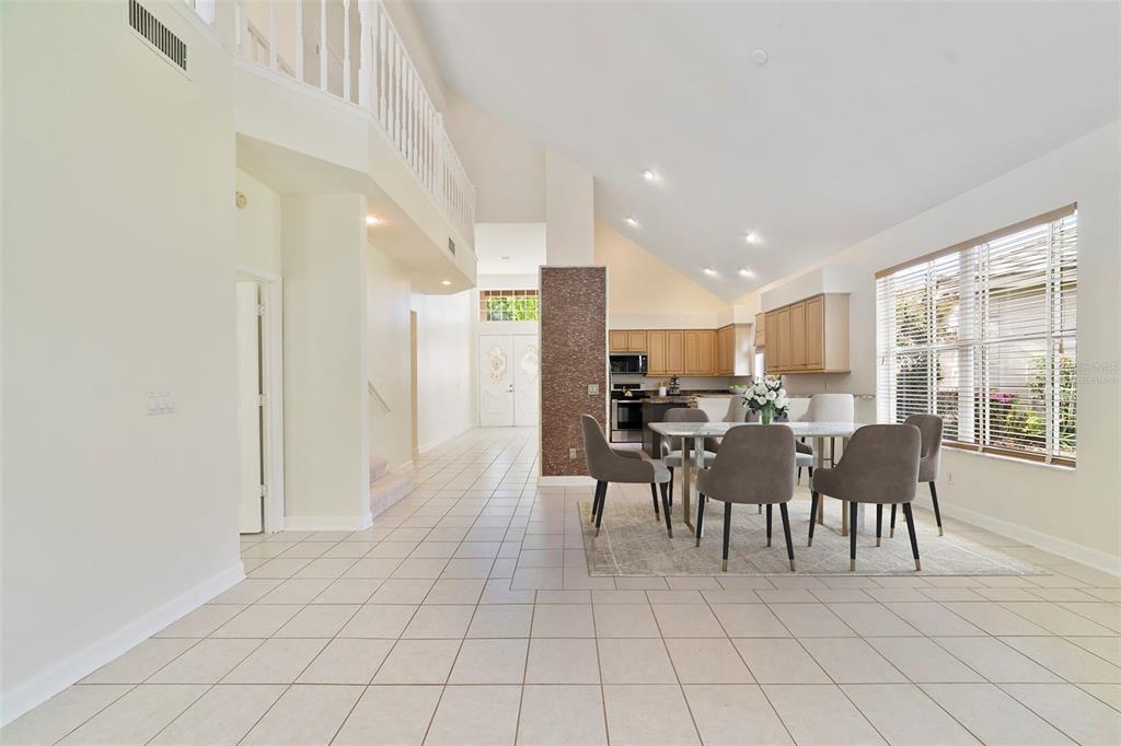A dining area with a table and chairs sits in an open-concept room with tile floors — 7291 HAWKSNEST BOULEVARD, ORLANDO, FL