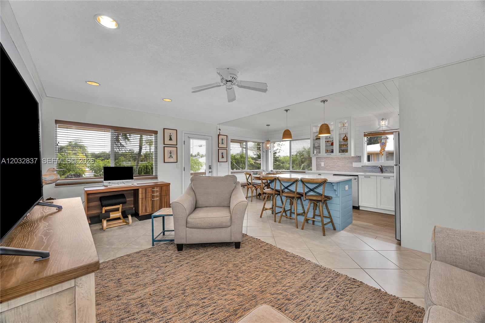 This open-concept living area features a kitchen with a blue island and tile flooring — 1050 SW 11th ST # 20L, Hallandale Beach FL 33009, HALLANDALE BEACH, FL