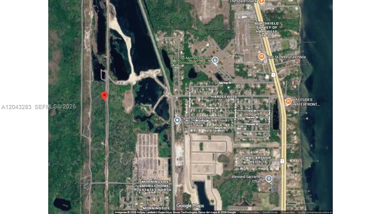 This is a satellite map showing a red location pin in a wooded area — COCOA BEACH, FL