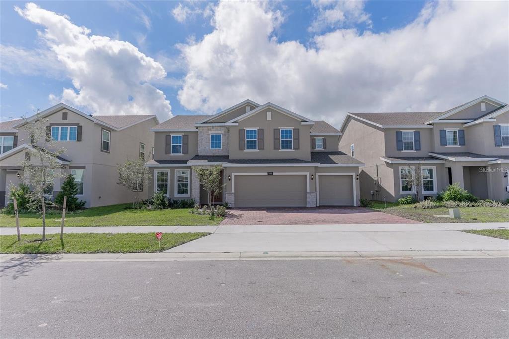 A two-story suburban house with a three-car garage and a paved driveway — 5018 DOWN COURT, ST CLOUD, FL