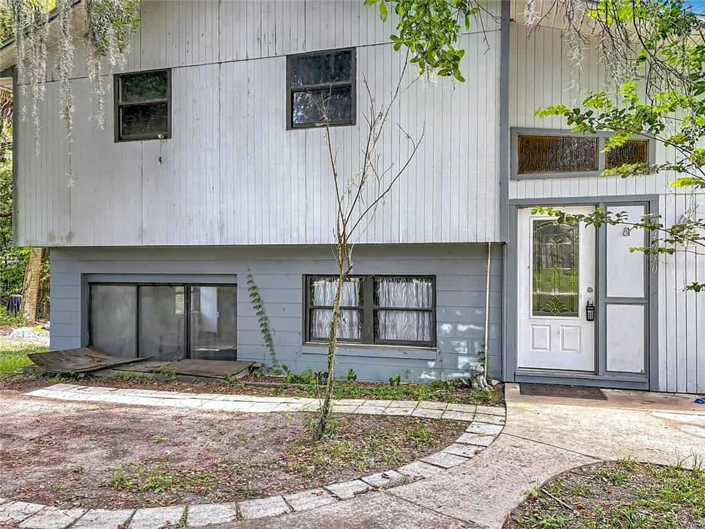 The exterior of a two-story house features vertical siding, a front door, and ground-level windows — 24930 AVENUE C, PAISLEY, FL
