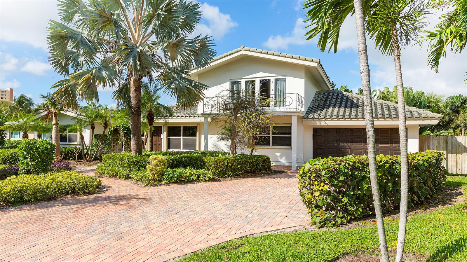A two-story house with a brick driveway, palm trees, and a balcony over the garage — 2003 Bay Drive, Pompano Beach FL 33062, POMPANO BEACH, FL