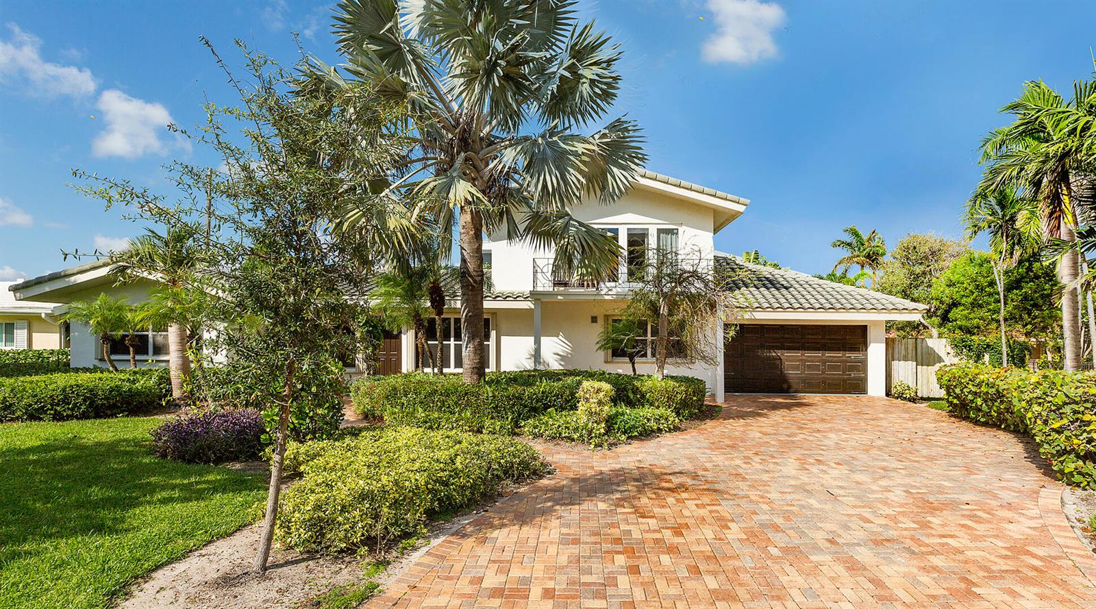 A two-story house with a brick driveway, palm trees, and a brown garage door — 2003 Bay Drive, Pompano Beach FL 33062, POMPANO BEACH, FL