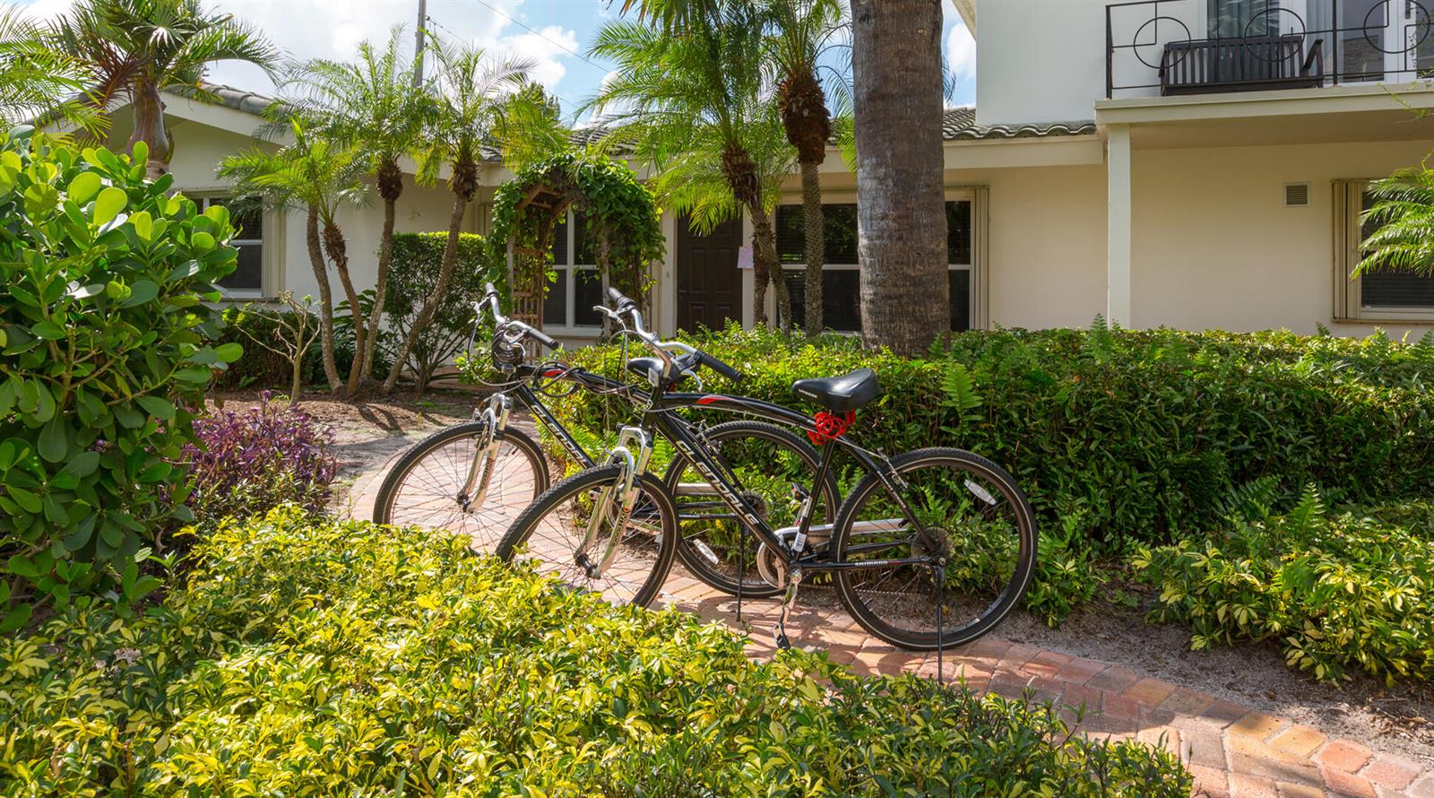 Two bicycles are parked on a brick walkway in front of a house with landscaping — 2003 Bay Drive, Pompano Beach FL 33062, POMPANO BEACH, FL