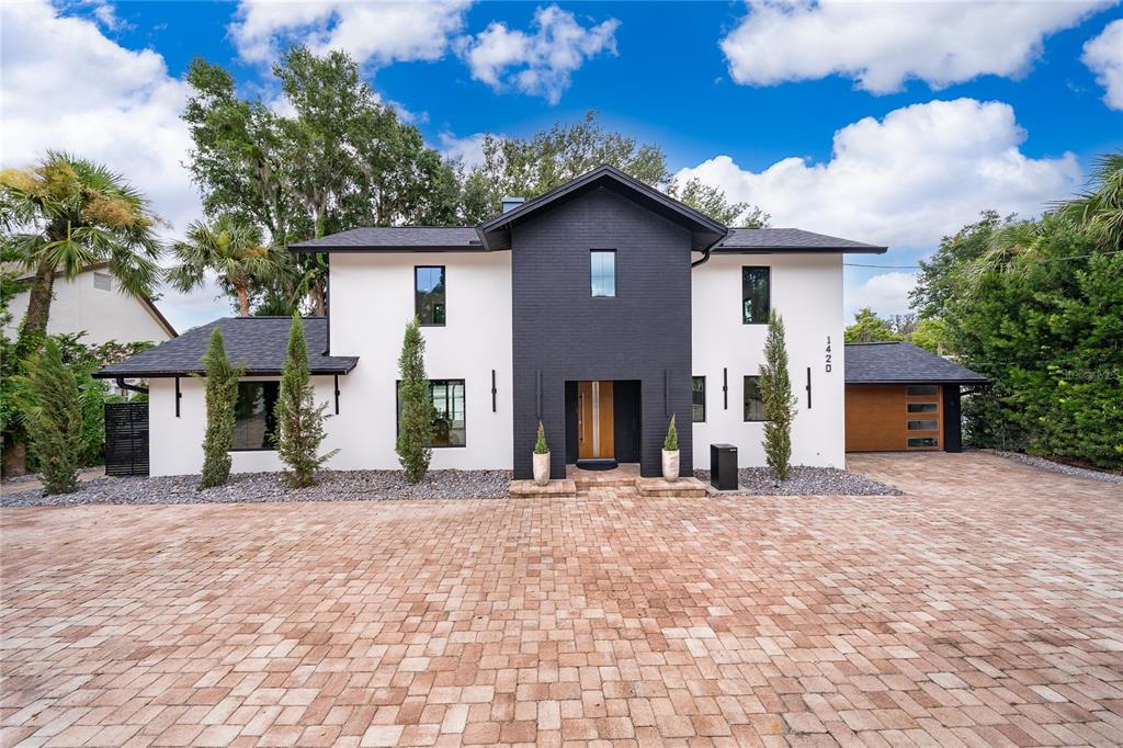 A modern two-story house with a black brick center section and white stucco exterior walls — 1420 ALOMA AVENUE, WINTER PARK, FL