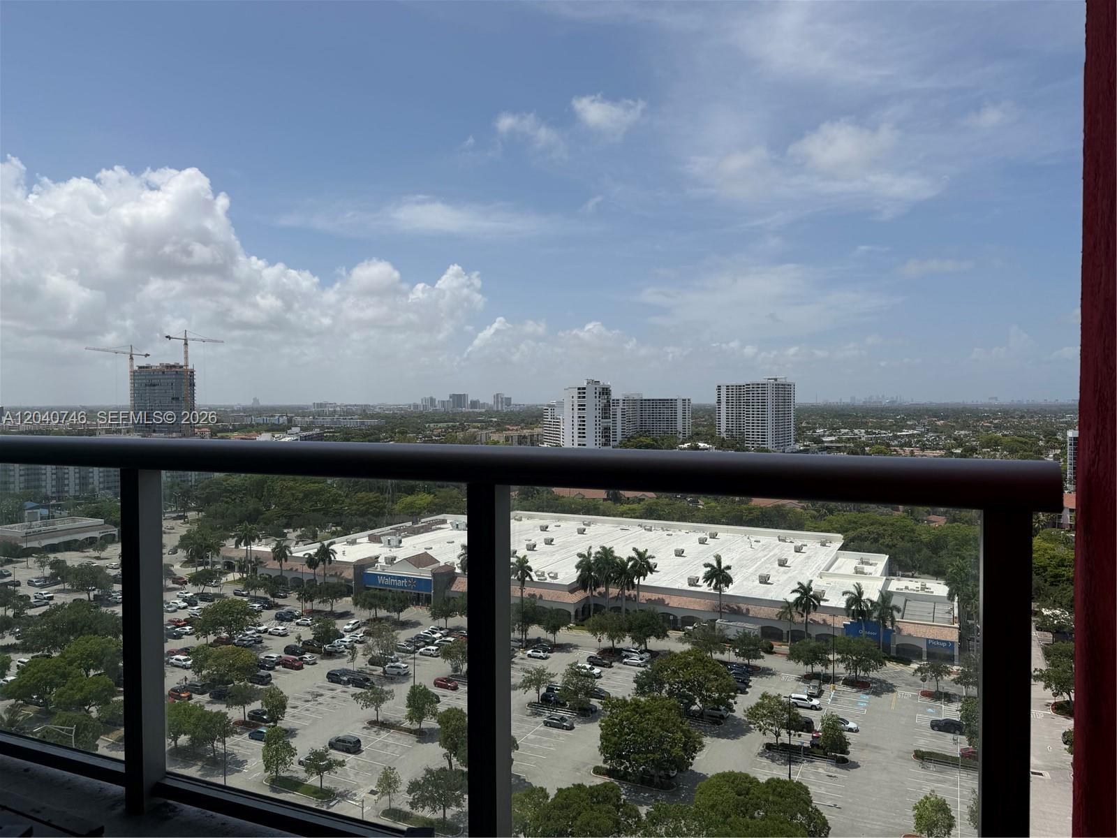 A high-angle view from a balcony overlooks a large parking lot and a Walmart store — 2602 E Hallandale Beach Blvd # R1910, Hallandale Beach FL 33009, HALLANDALE BEACH, FL
