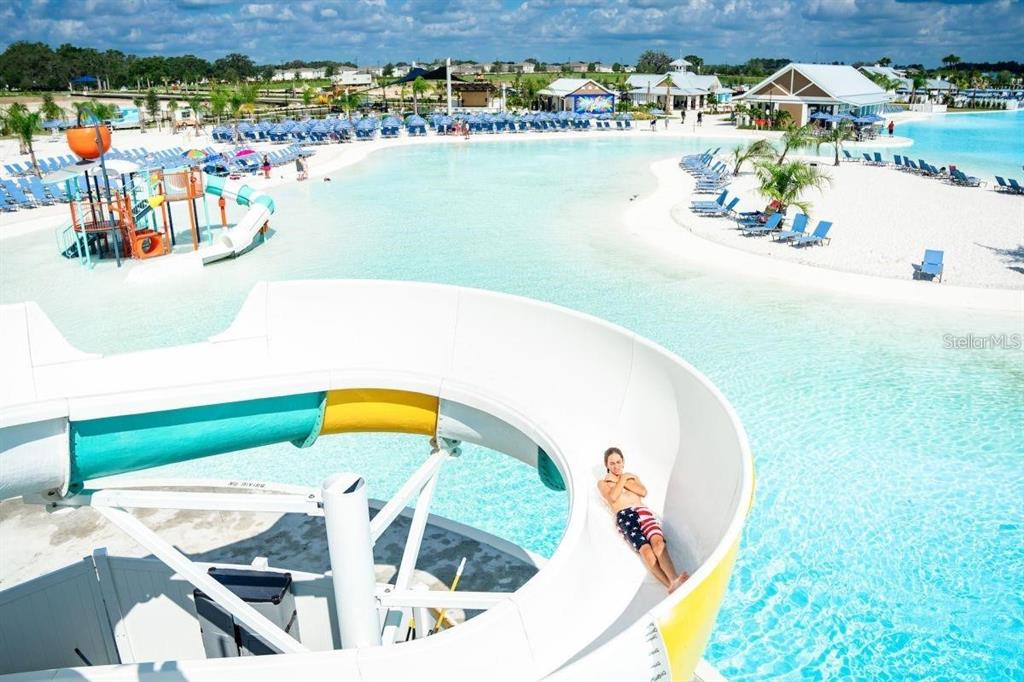 A person slides down a water slide at a large outdoor lagoon pool — 32813 OSPREY PEAK WAY, SAN ANTONIO, FL