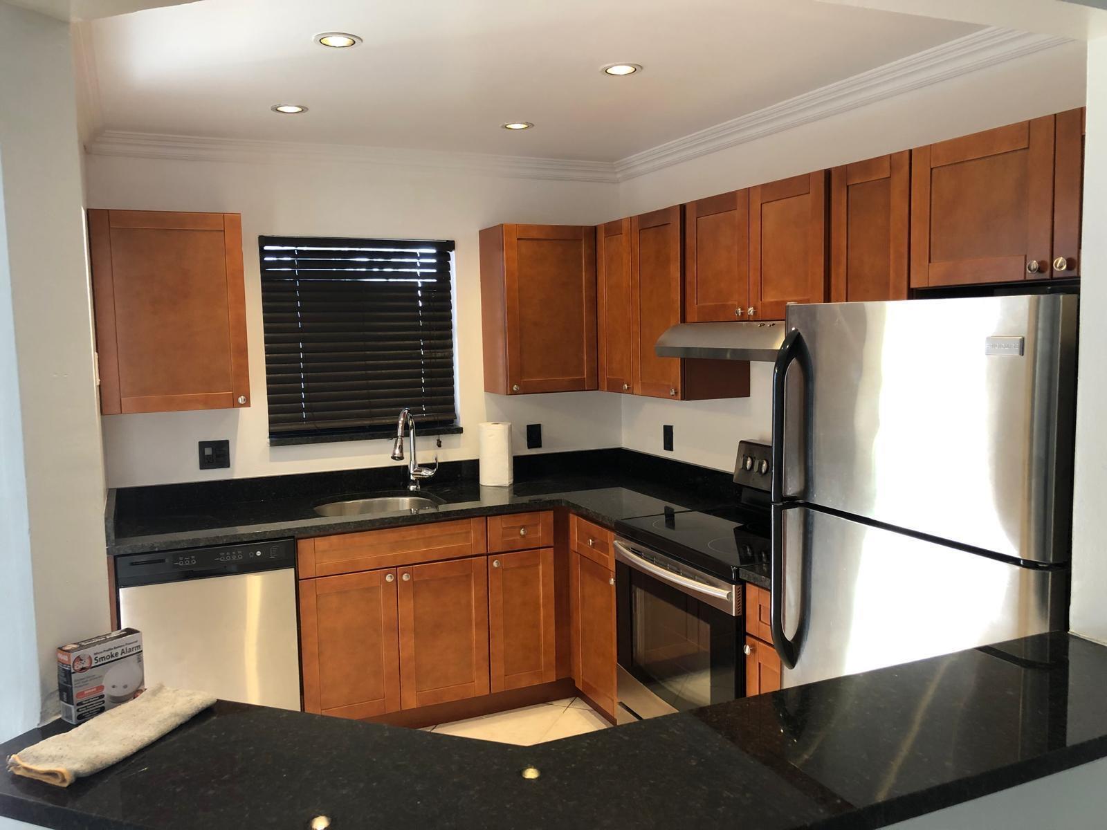 A kitchen features wood cabinets, black granite countertops, stainless steel appliances, and a window with blinds — 21911 Lake Forest Circle # 204, Boca Raton FL 33433, BOCA RATON, FL