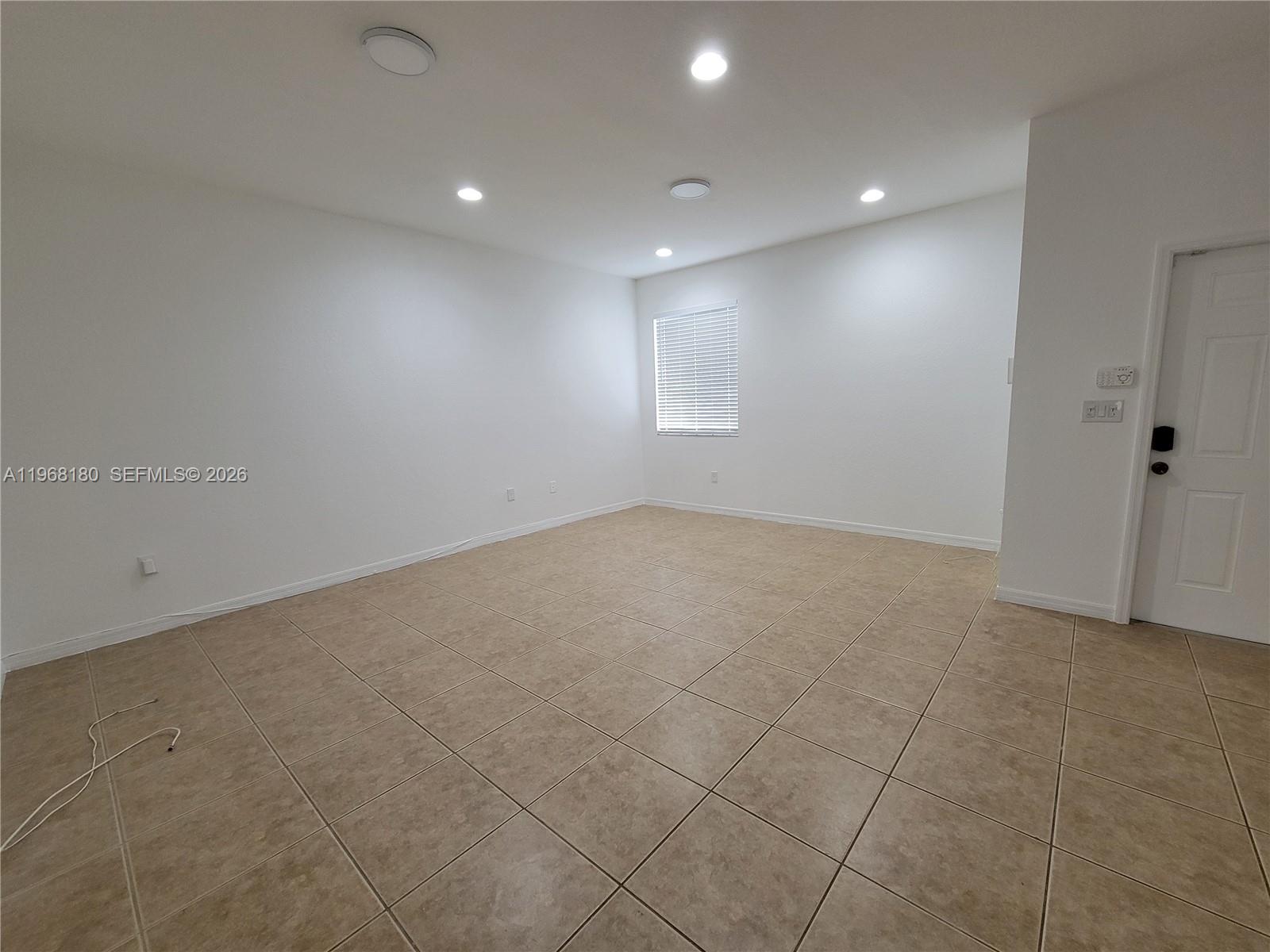 An empty room features white walls, recessed lighting, and light brown tile flooring — 8938 SW 19th St # 904, Miramar FL 33025, MIRAMAR, FL