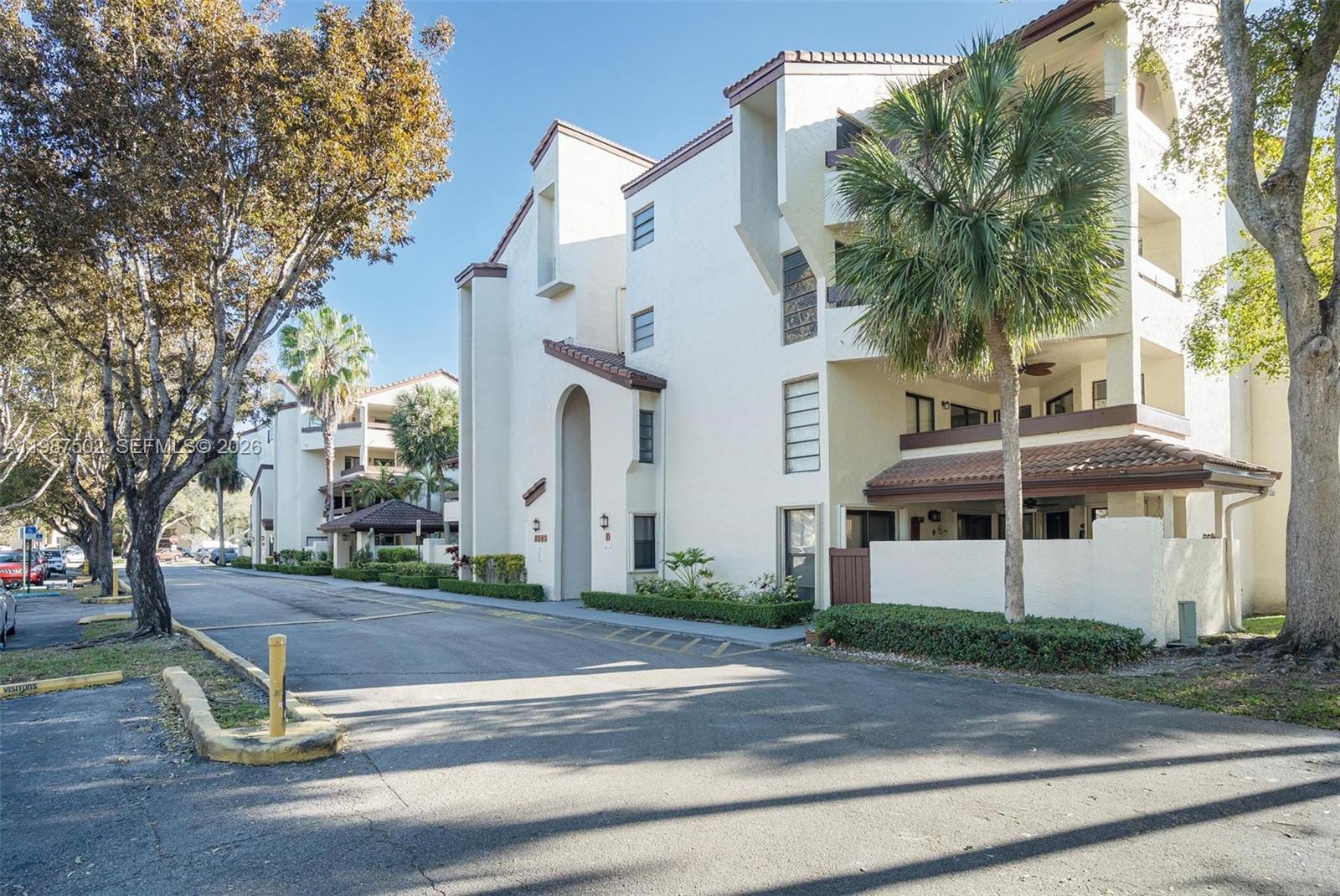 A multi-story residential building with white stucco walls and a palm tree in front — 9040 SW 125th Ave # D408, Miami FL 33186, MIAMI, FL