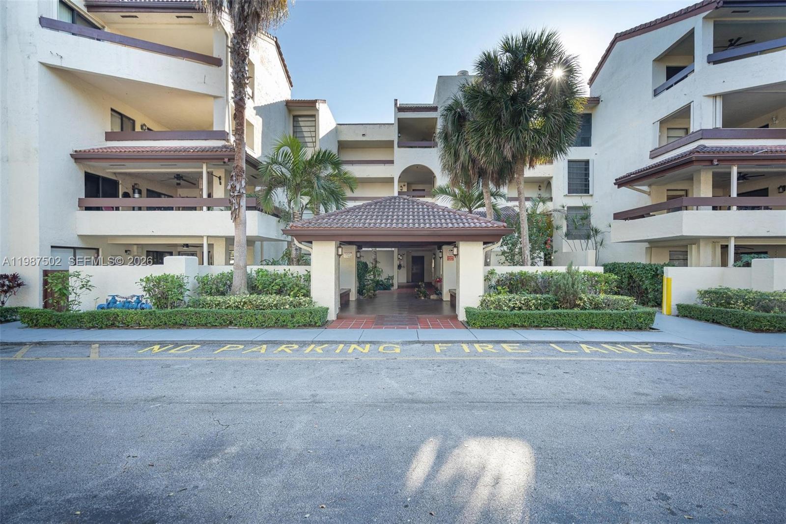A multi-story apartment building features a covered entryway and a paved fire lane — 9040 SW 125th Ave # D408, Miami FL 33186, MIAMI, FL