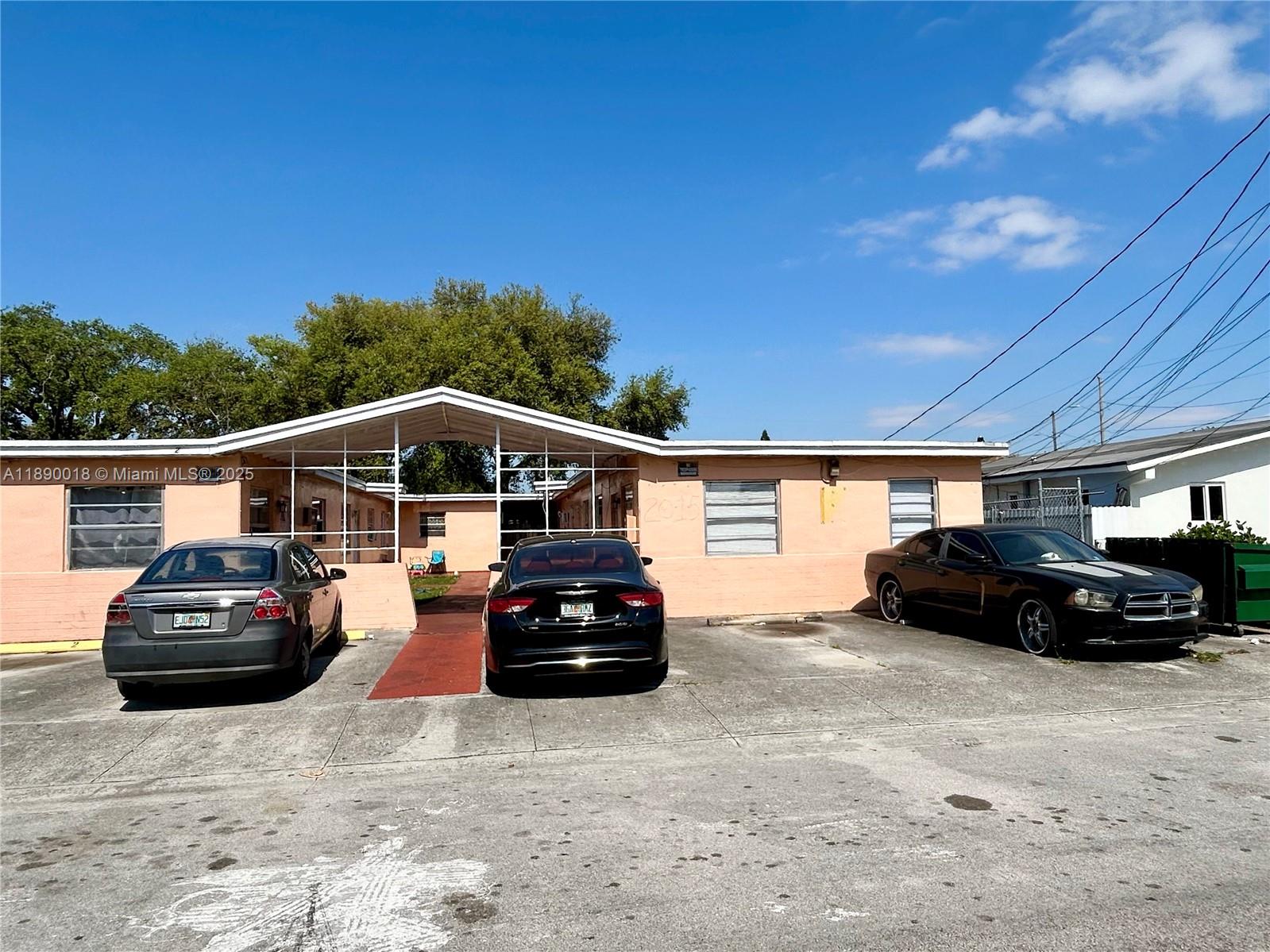 A single-story peach-colored building with a central covered walkway and three parked cars — 2013 Washington Ave, Opa-Locka FL 33054, OPA-LOCKA, FL
