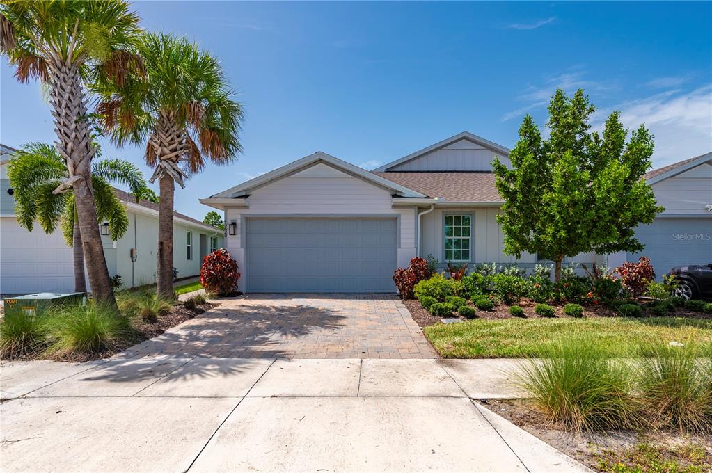 A single-story house with a gray garage door, a paved driveway, and palm trees — 43620 SPARROW DRIVE, PUNTA GORDA, FL