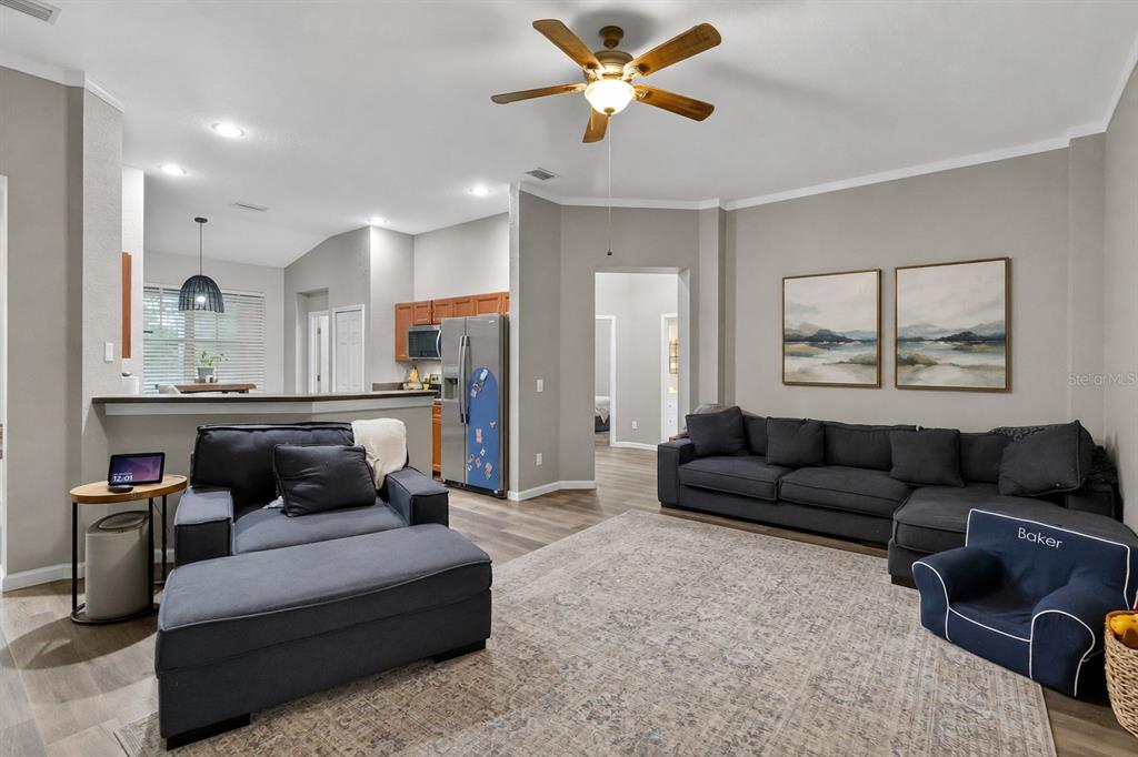 A living room features a large sectional sofa, a ceiling fan, and an open kitchen — 11326 LAUREL BROOK COURT, RIVERVIEW, FL