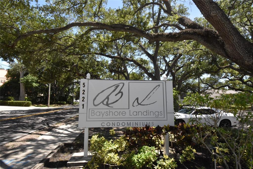 A sign for Bayshore Landings Condominiums stands under large trees beside a road — 5221 BAYSHORE BOULEVARD UNIT 45, TAMPA, FL