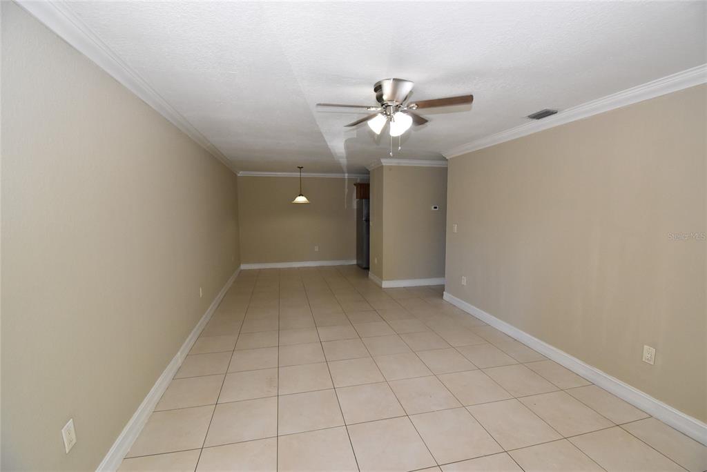 An empty room with beige walls, tile flooring, a ceiling fan, and a pendant light — 5221 BAYSHORE BOULEVARD UNIT 45, TAMPA, FL