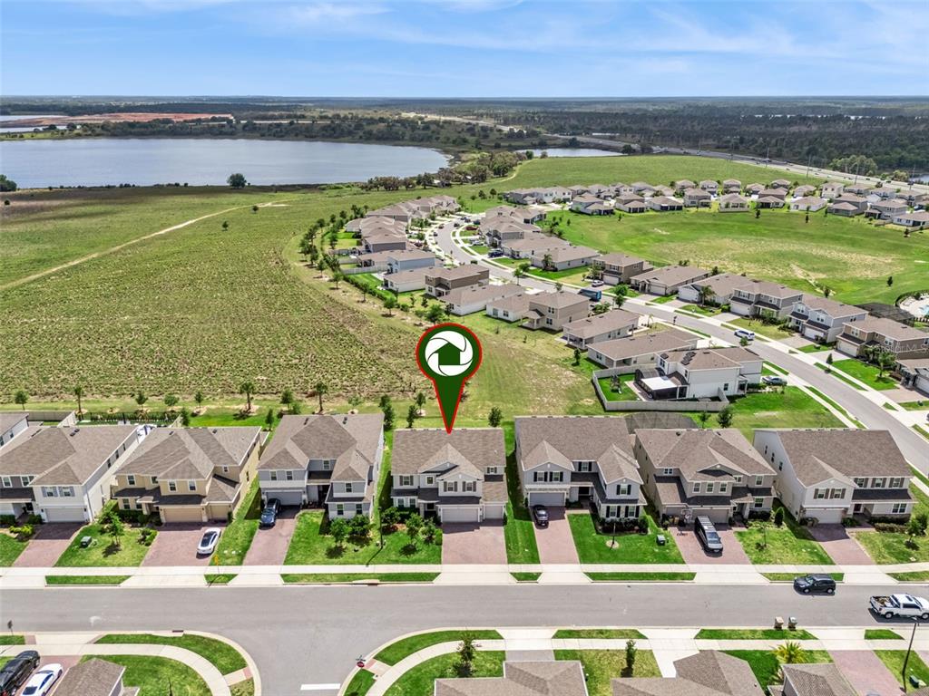 A two-story suburban house with a three-car garage and a brick driveway at sunset — 14321 CRESTAVISTA AVENUE, CLERMONT, FL