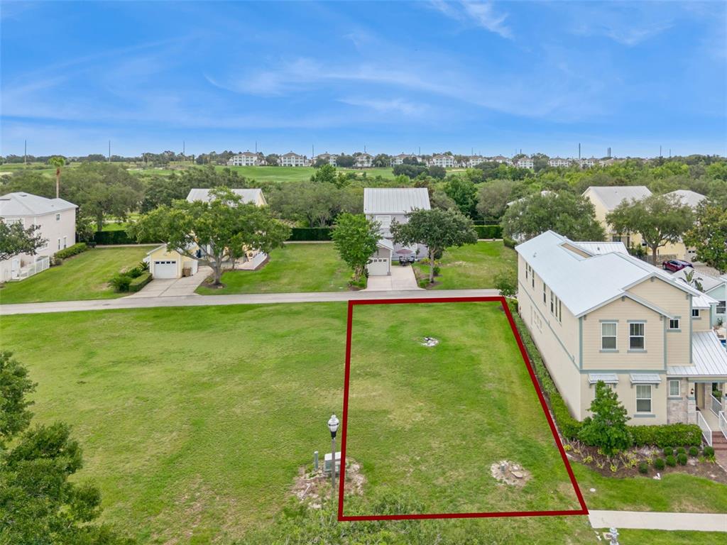 An aerial view shows a vacant rectangular residential lot outlined in red next to a house — 1529 FAIRVIEW CIRCLE, REUNION, FL