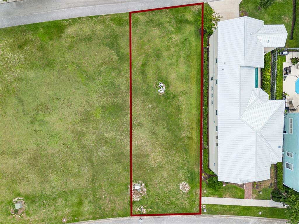 An aerial view shows a rectangular vacant lot outlined in red between a street and a house — 1529 FAIRVIEW CIRCLE, REUNION, FL
