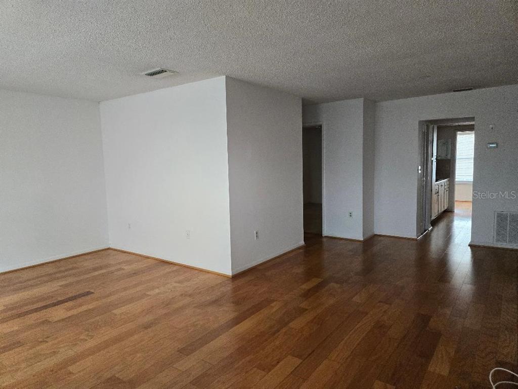 An empty room with white walls, a textured ceiling, and hardwood flooring — 3128 59TH STREET S UNIT 205, GULFPORT, FL