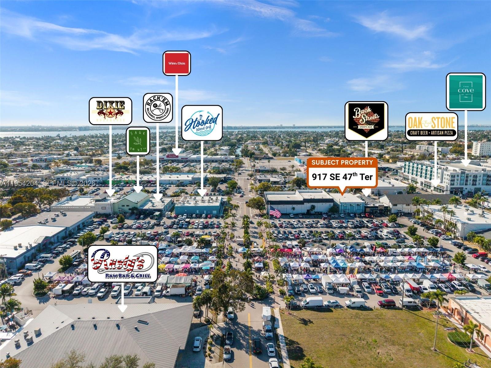 This aerial view shows a commercial district with a large parking lot and surrounding businesses — 917 SE 47th Ter, Cape Coral FL 33904, CAPE CORAL, FL