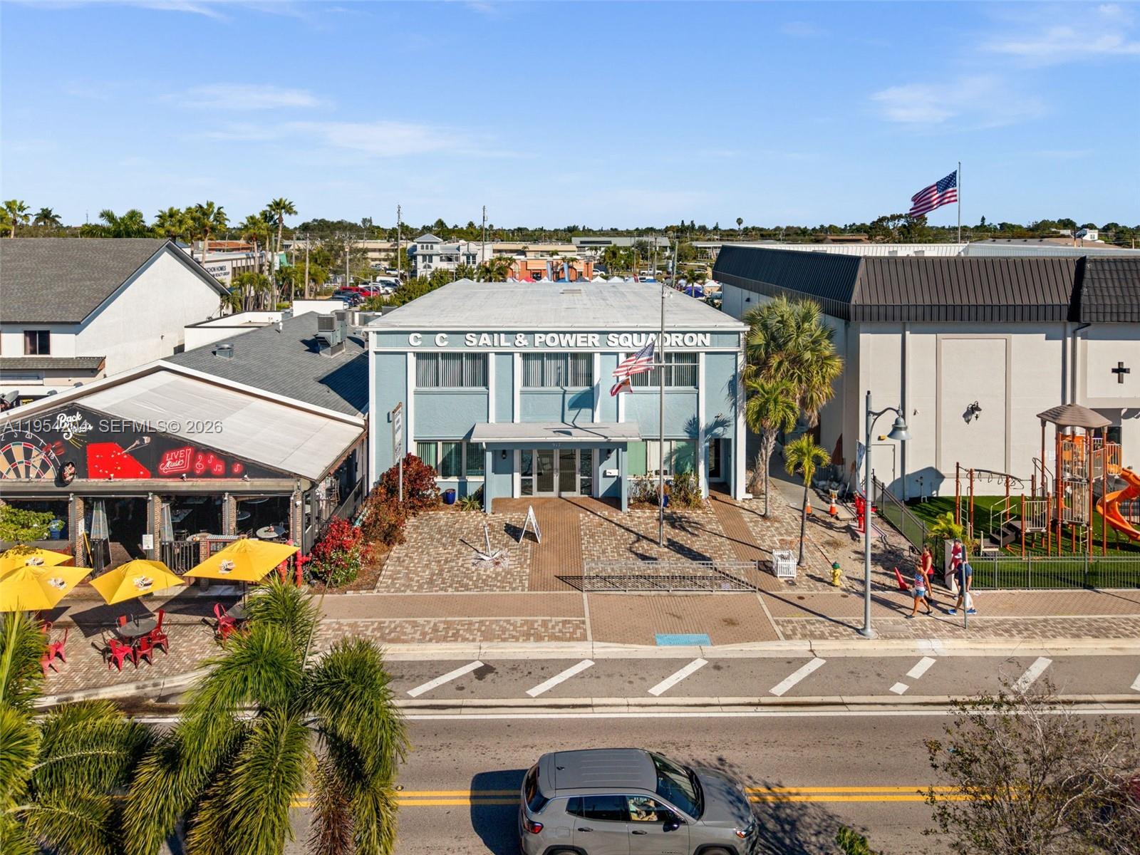 An exterior view of the blue C C Sail & Power Squadron building with a playground — 917 SE 47th Ter, Cape Coral FL 33904, CAPE CORAL, FL