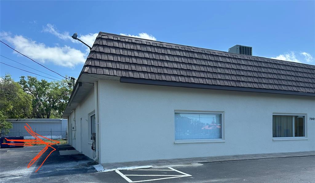 The exterior of a commercial building features a dark mansard roof and white stucco walls — 7904 US HIGHWAY 19, PORT RICHEY, FL