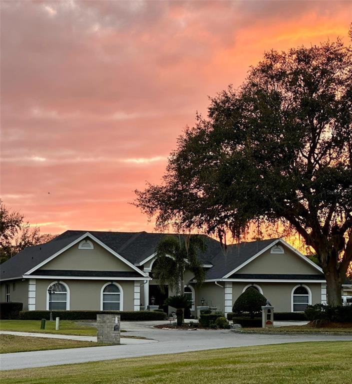 An aerial view shows a house with a pool, screened lanai, and circular driveway — 83 JENNI ASHLEY COURT, WINTER HAVEN, FL