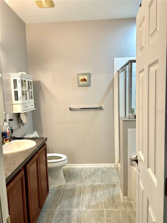 A bathroom features a vanity with a sink, a toilet, and a glass-enclosed shower — 17274 ASMARA COURT, PUNTA GORDA, FL
